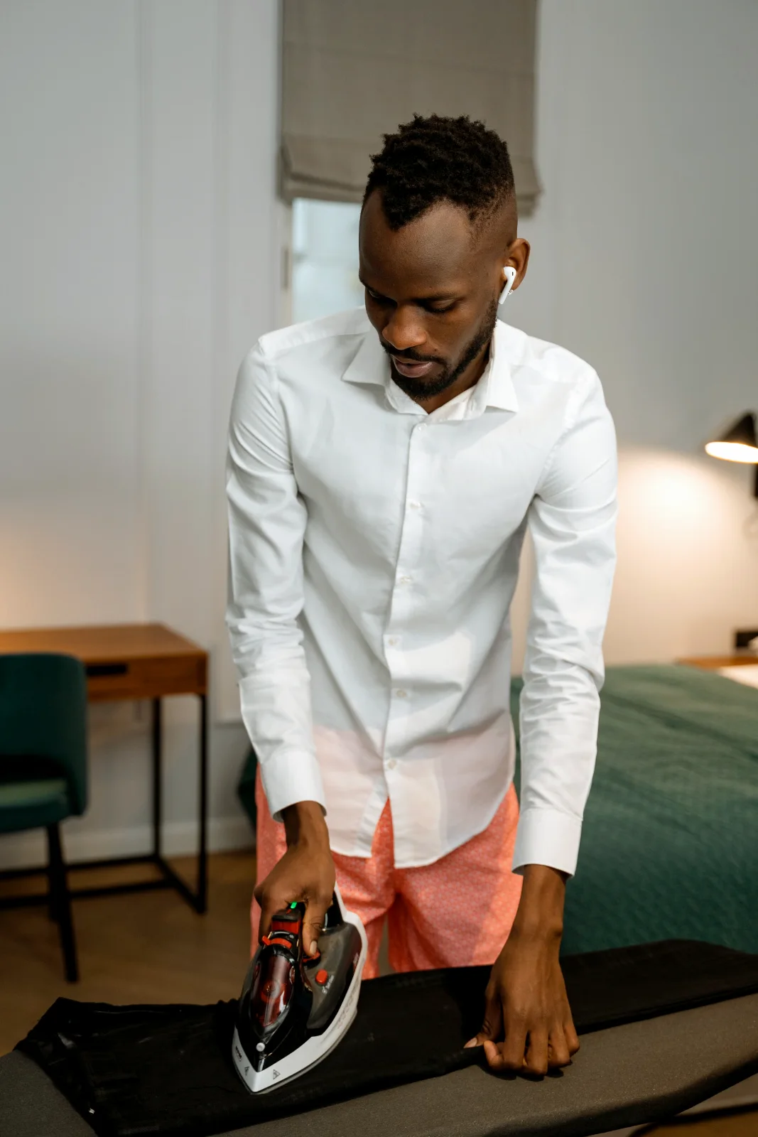 A man ironing a crisp white shirt